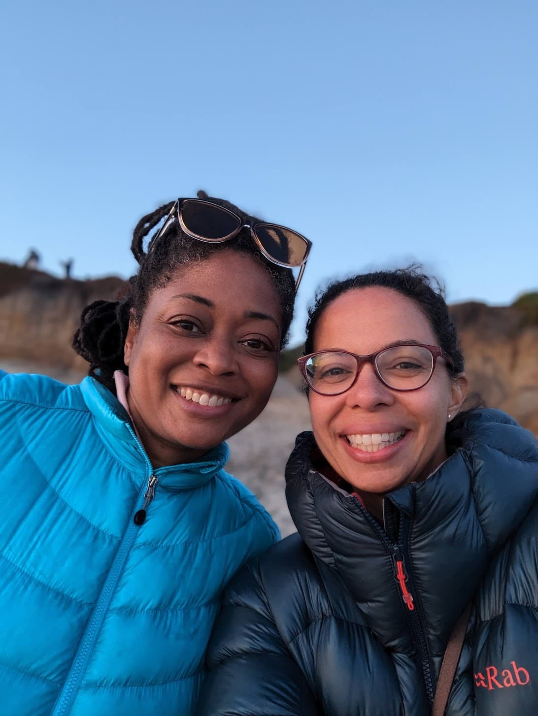 Two women smiling warmly in outdoor gear - Valencia M. and friend