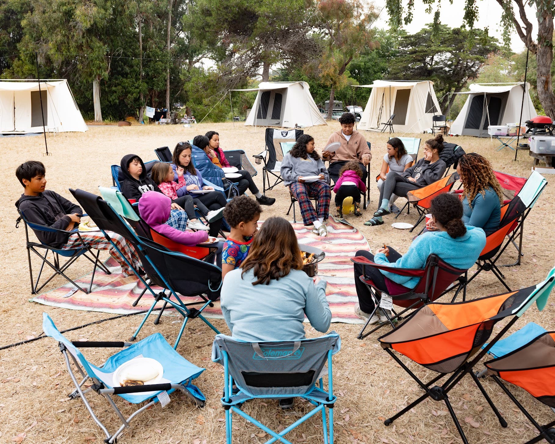 Families seated in a circle at camp