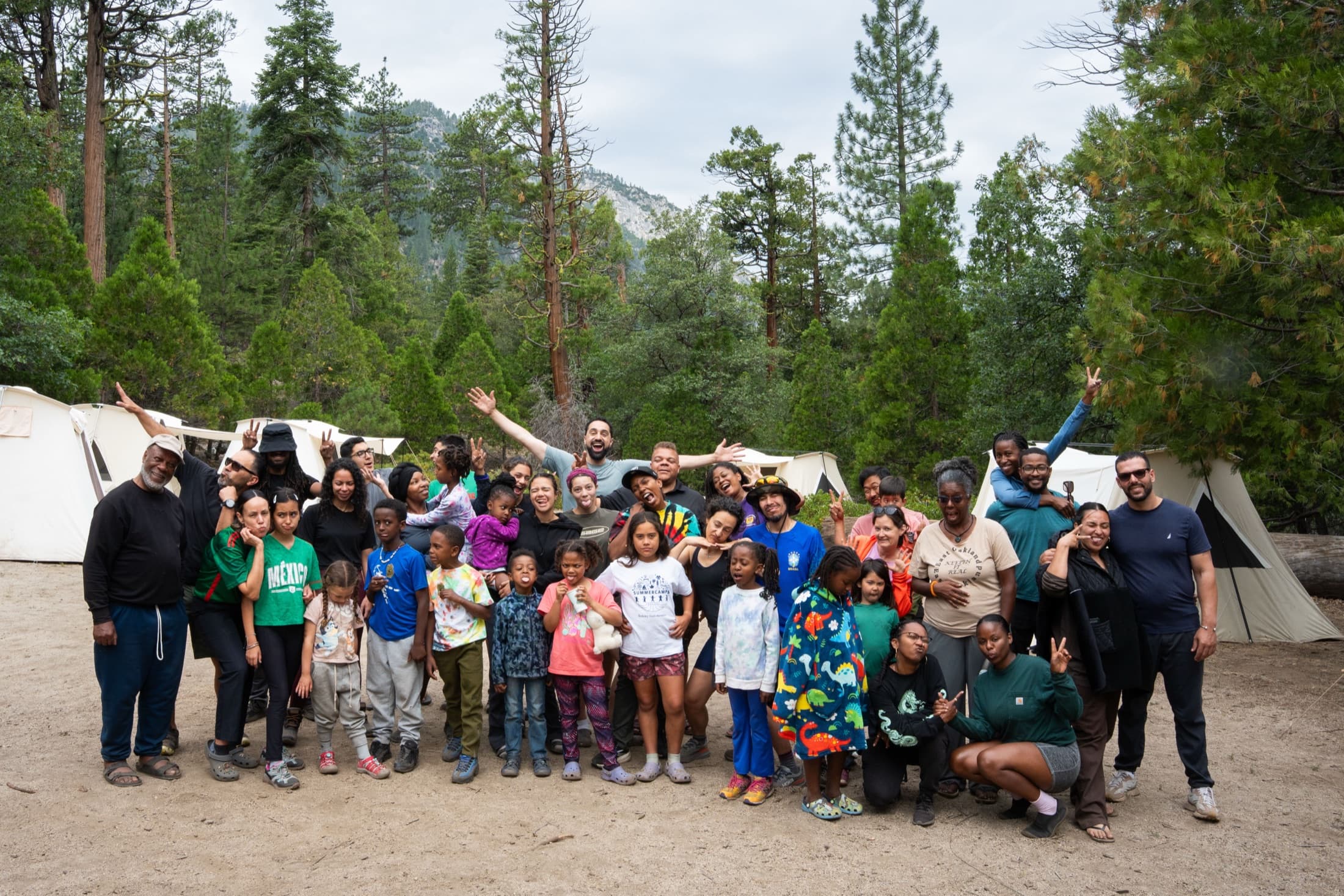 About forty five Outdoorithm Collective members, adults and children, gathered in front of the canvas tent village at Kings Canyon
